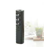 Black remote control on a white surface with a blurred background